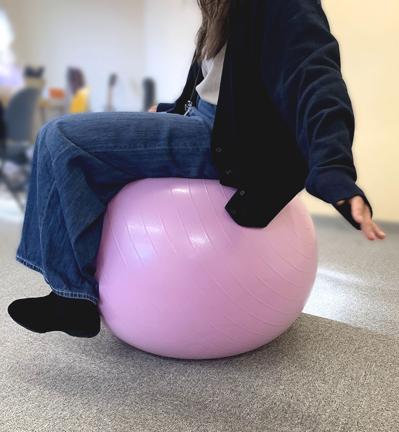 イデアシーディー社内でバランスボールに乗っている女性社員
