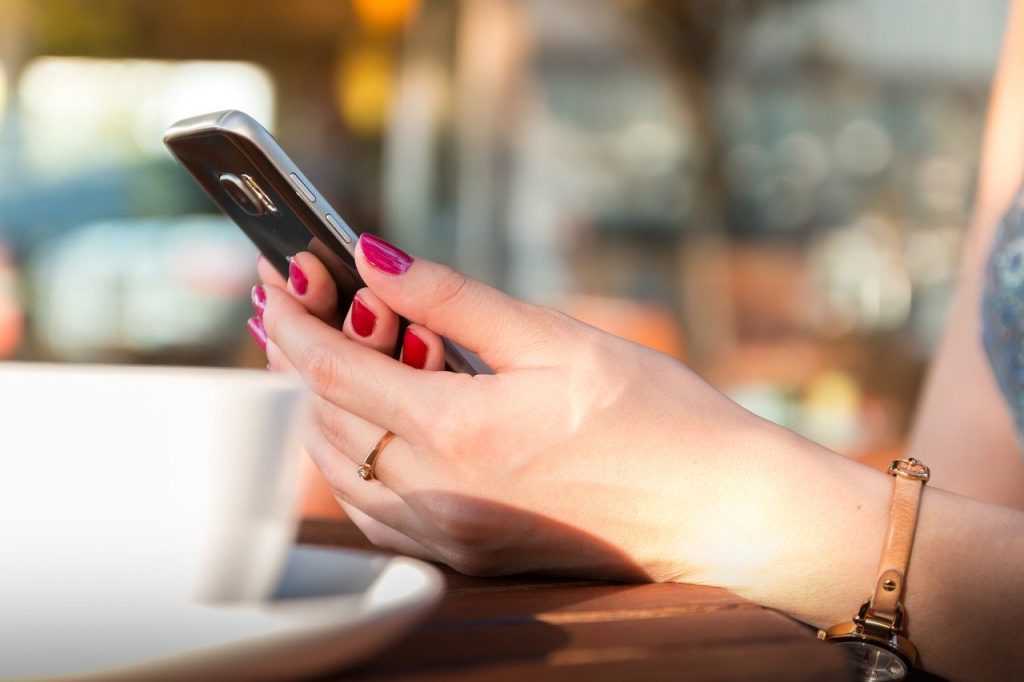 服装髪型自由のWebディレクター採用、スマホを見ているイメージ。